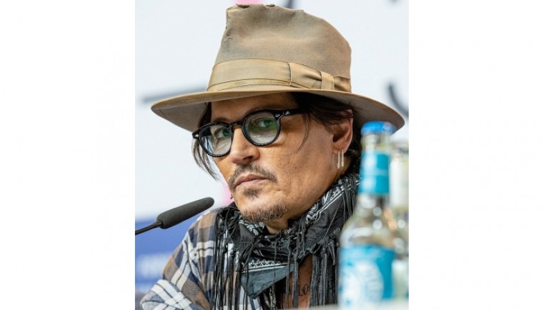 Johnny Depp looks disheveled as he's escorted out of hotel